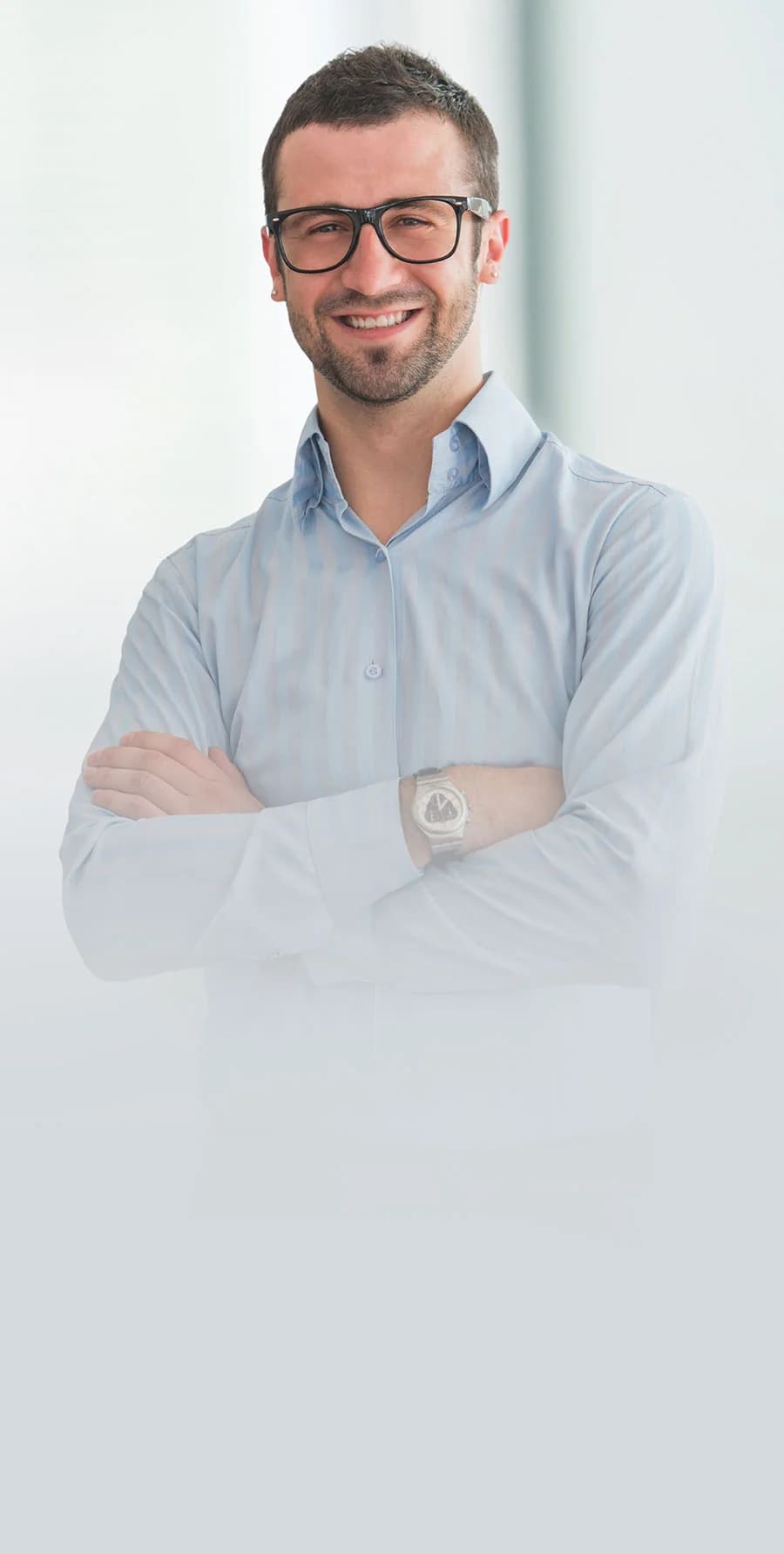 Mężczyzna w biurze z założonymi rękami.